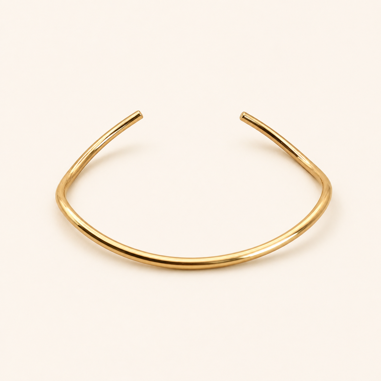Drift Cuff i 316 kirurgiskt stål och 18k PVD-guld, ett öppet guldfärgat cuff-armband mot ljus neutral bakgrund.