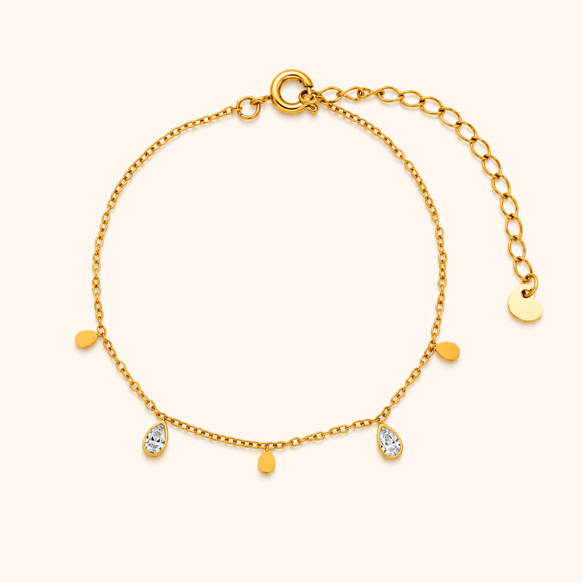 Glimmer Bracelet i 18k PVD-guld med droppformade detaljer och zircon på ljus bakgrund
