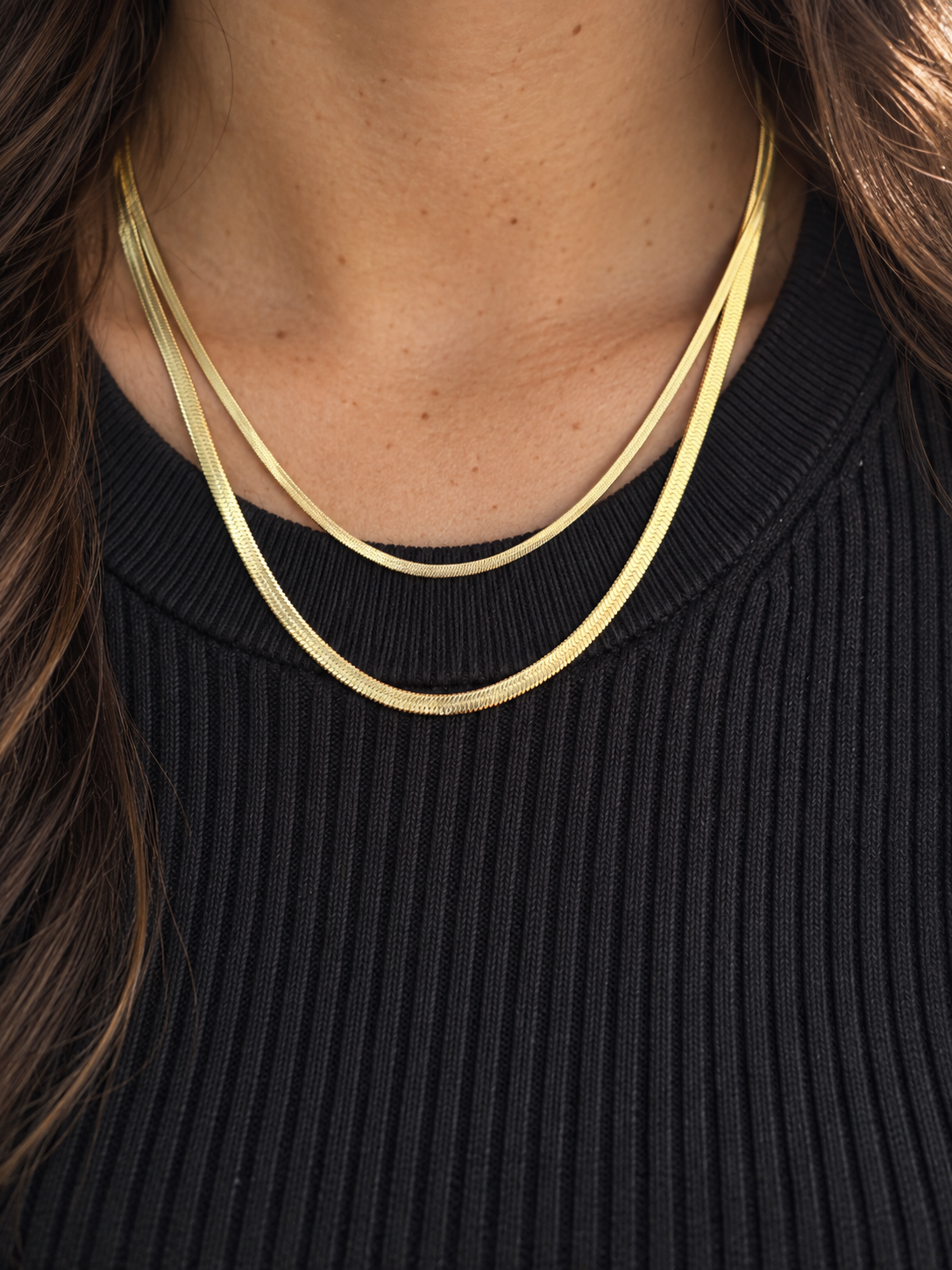 Lune Necklace 3mm och 1.7mm i guld burna i lager på halsen med svart topp.
