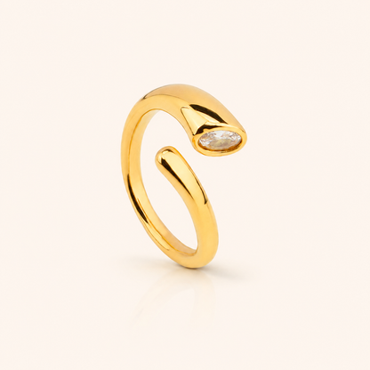 Aero Ring i 18k PVD-guld med öppen bågform och infattad sten på ljus bakgrund