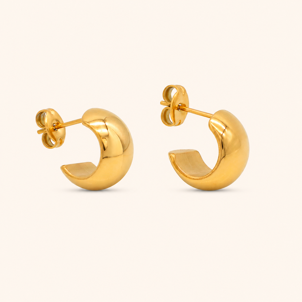 Crescent Hoop örhängen i 18k PVD-guld med fyllig rundad form på ljus bakgrund