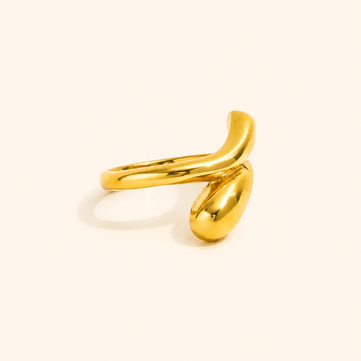 Flux Ring i 18k PVD-guld med skulptural vriden form på ljus bakgrund