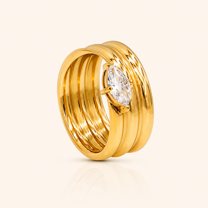 Maris Ring i 18k PVD-guld med dubbla band och infattad sten på ljus bakgrund