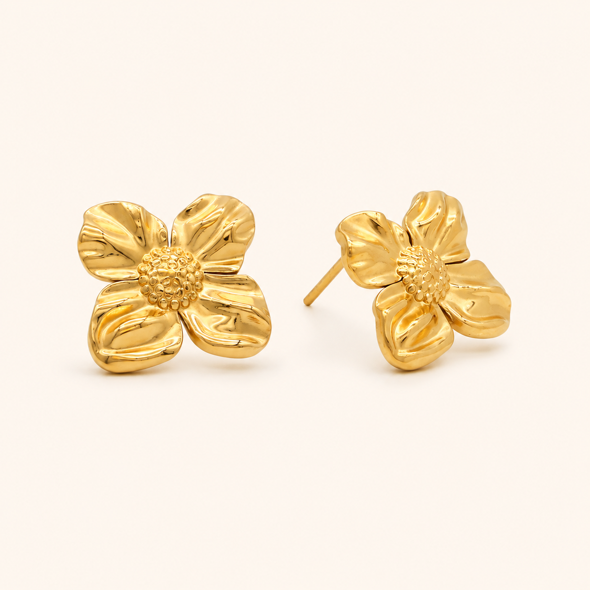 Petal Stud blomörhängen i 18k PVD-guld med skulpturala kronblad på ljus bakgrund