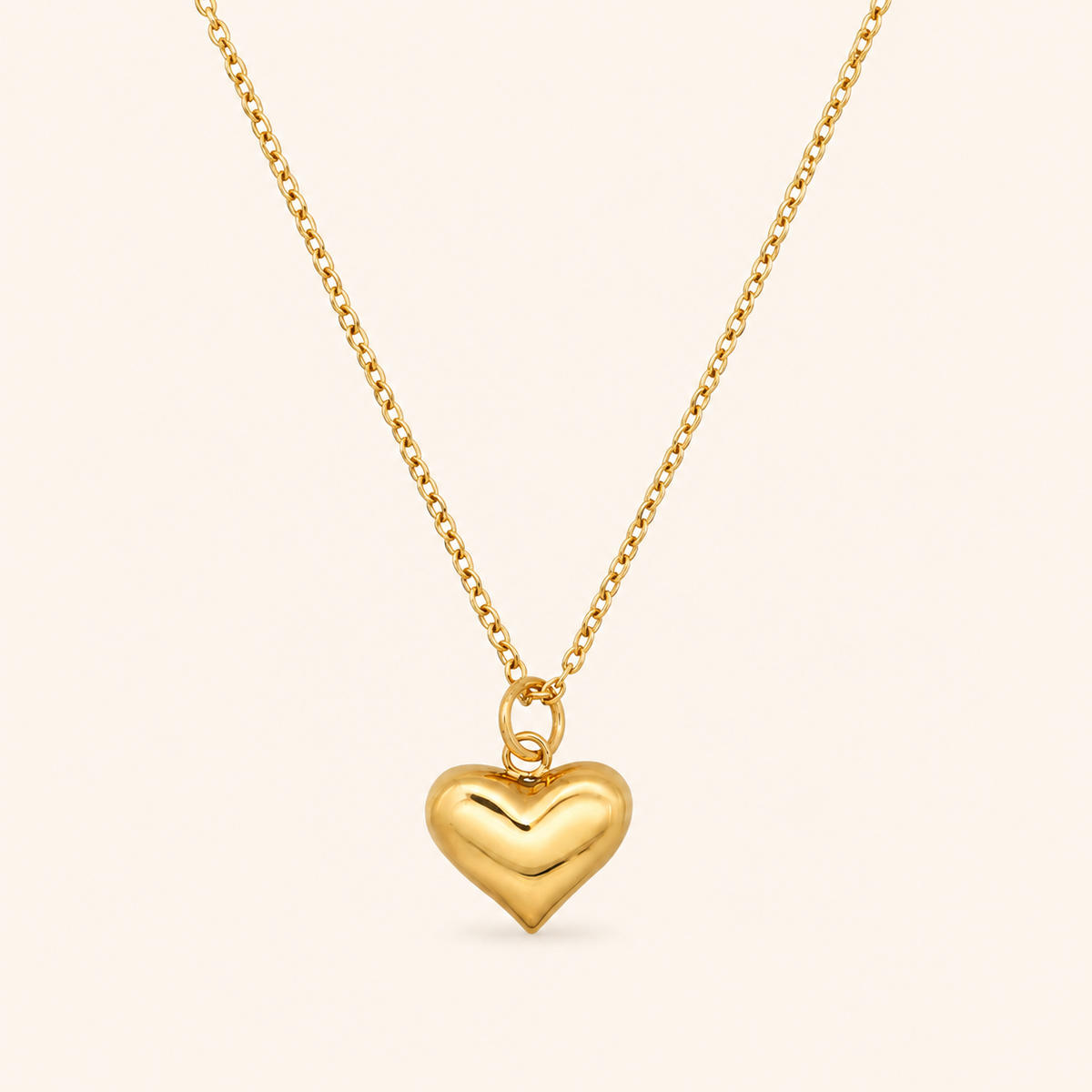Pulse Necklace i 18k PVD-guld med fylligt hjärtformat hänge på ljus bakgrund.