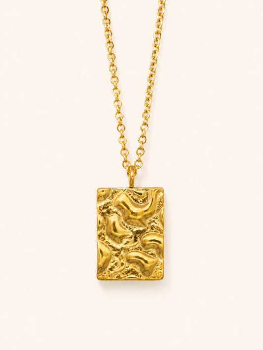 Relief Necklace i 18k PVD-guld med rektangulärt texturerat hänge på ljus bakgrund