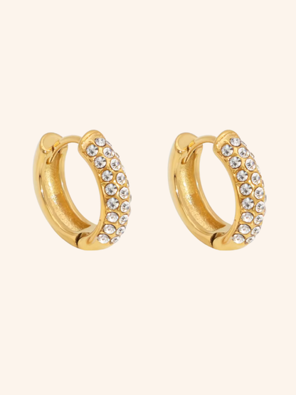 Rime Hoop huggie hoops i 18k PVD-guld med tätt satta zircon på ljus bakgrund