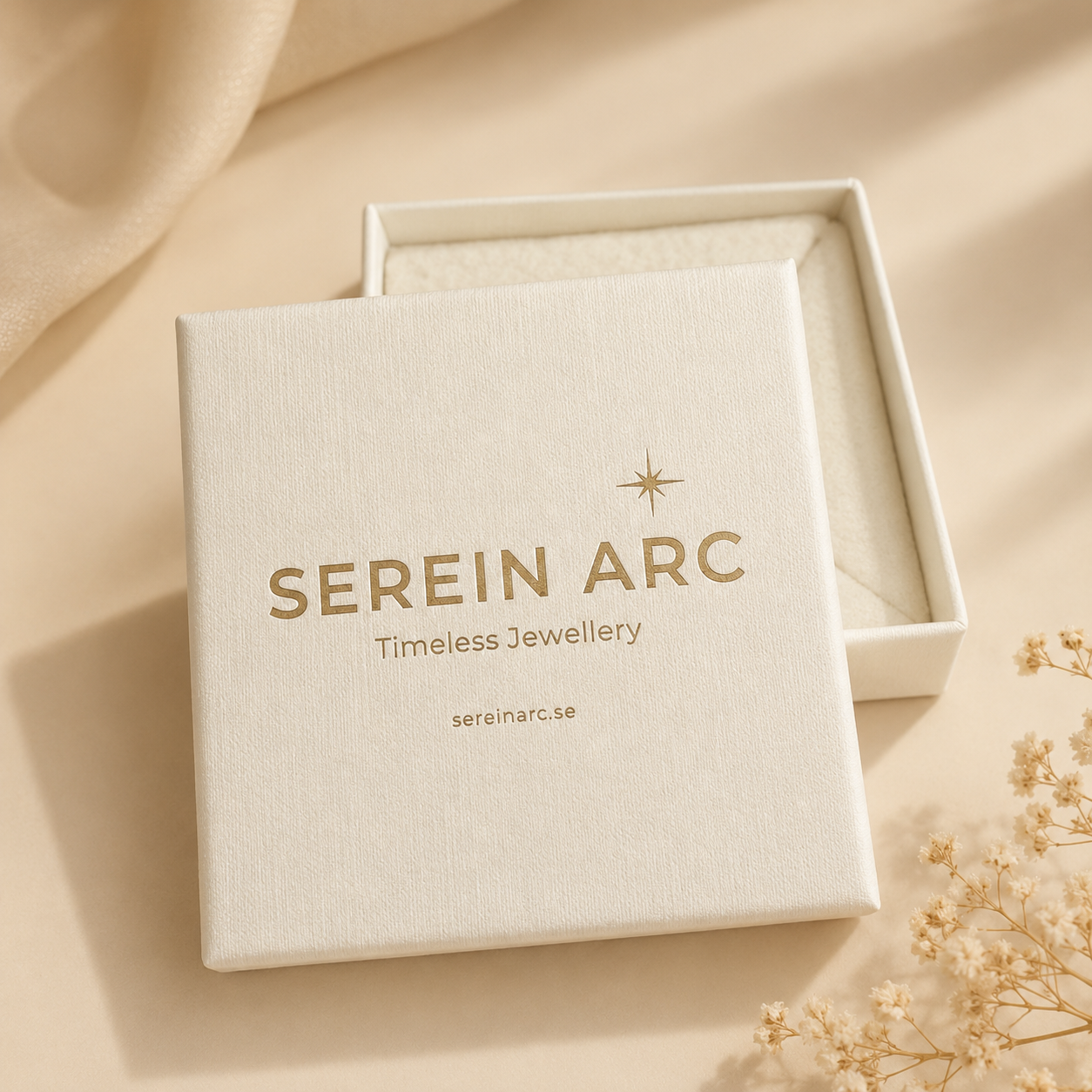 Serein Arc smyckesask i varm beige ton med logotyp, placerad på mjuk neutral bakgrund med ljusa blommor.
